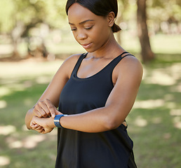 Image showing Time, fitness or black woman in nature with a smartwatch to monitor heart health in training, exercise or park workout. Wellness, digital or girl runner checking running performance stats in Nigeria