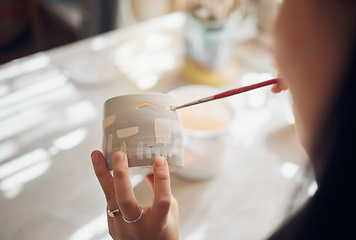 Image showing Woman hands, pottery studio and painting cup in workshop for sculpture, creative manufacturing or design. Painter, ceramics product and brush process, artistic pattern or production in small business