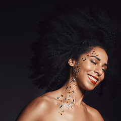 Image showing Woman face, fashion body art or rhinestone jewels on black background studio for diamond sparkle, festival accessory or creative party crystal. Happy smile, beauty model skin or makeup cosmetics gems