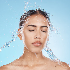 Image showing Woman, washing face or water splash skincare on blue background studio in healthcare wellness, Brazil bathroom hygiene or self care grooming. Beauty model, water drop or facial cleaning in wet shower