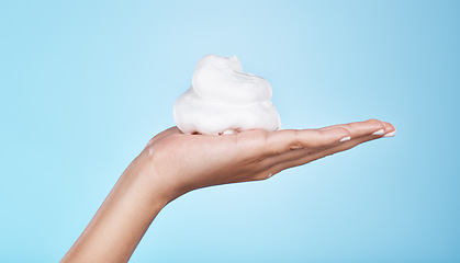 Image showing Skincare, wellness and hands with foam on blue background for treatment, grooming and body care. Cosmetics, spa aesthetic and palm with shaving cream, soap and cleaning products isolated in studio