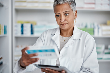 Image showing Pharmacist woman, tablet and reading box for information, stock or wellness in store with focus. Senior pharma expert, digital tech and stock in pharmacy for medicine, health or online help in Mumbai