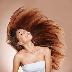 Image showing Hair care, wellness and woman in studio with salon, keratin or botox health hair treatment. Cosmetics, happy and female model from Brazil with a long, healthy and brown hair style by brown background