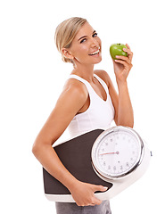 Image showing Woman, apple and carrying scale for diet, weight loss or healthy nutrition against a white background. Portrait of happy isolated female with smile for organic, vitamins and dieting food for measure