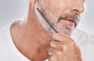 Image showing Face, senior man and beard comb in studio isolated on a gray background. Skincare, facial hair care and elderly retired male model with product, tool or accessory for grooming, beauty and aesthetics.