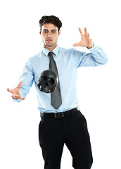 Image showing Business man, black skull and levitation in studio isolated on a white background. Magician, spirit and male employee levitating head or scalp in air for evil, death or occult, voodoo or magic trick.