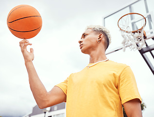 Image showing Sports, fitness and man spinning basketball on court outdoors before workout, exercise or practice. Basketball court, balance and young male player with ball on finger getting ready for training.