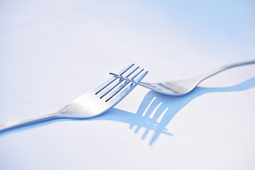 Image showing Dinner, shadow and forks on a table for partnership, teamwork and collaboration on a blue studio background. Creative, design and kitchen utensils with reflection of solidarity and team work