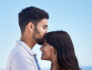 Image showing Couple, forehead kiss and love outdoor with commitment, trust and happy together with bonding and care. Date, romance and relationship with young man, woman profile and smile against sky background