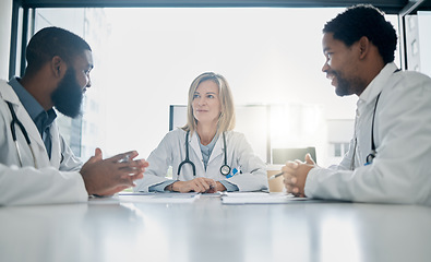 Image showing Healthcare, meeting and team of doctors talking in hospital, clinic or health care facility boardroom. Teamwork, communication and medical workers in discussion, conversation and speaking with paper