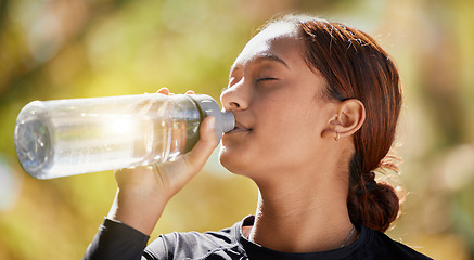 Image showing Fitness, nature and woman drinking water after running for hydration, refresh and thirst. Sports, runner and female athlete enjoying a drink after cardio training for a race, marathon or competition.