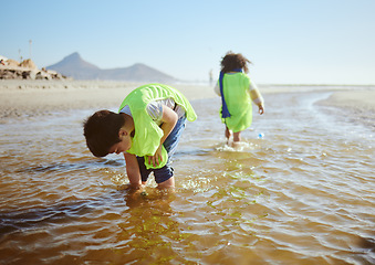 Image showing Ocean, environment and young child cleaning for climate change and sustainability, environmental and volunteer for Earth day. Water pollution, nature and kids clean up beach and eco friendly activism