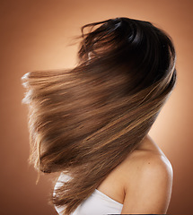 Image showing Beauty, hair and salon with a model woman in studio on a brown background for keratin haircare treatment. Health, luxury and hair care with a young female posing to promote a natural hairstyle