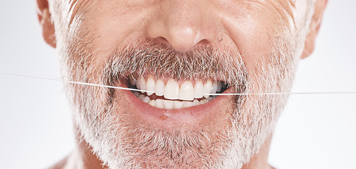 Image showing Dental, floss and mouth of senior man in studio isolated on a gray background. Hygiene, cleaning and elderly male model with product flossing teeth for oral wellness, tooth care and healthy gums.