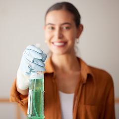 Image showing Woman, spray bottle and cleaning service with a smile in a house or apartment for safety with gloves and chemical. Female cleaner showing liquid product to clean dirt, dust and bacteria at home