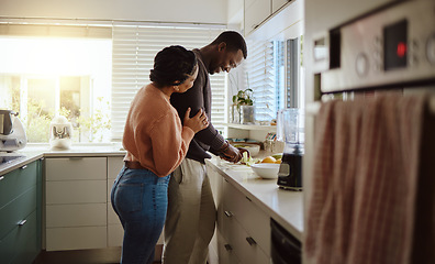 Image showing Black couple, cooking and helping with food in kitchen at home while together to cook healthy food. Happy young man and woman in their house or apartment to bond and prepare lunch or dinner with love