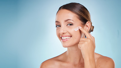 Image showing Skincare, beauty and portrait of a woman with face cream for health, wellness and natural face routine. Cosmetic, happy and model with facial lotion, spf or creme isolated by a blue studio background