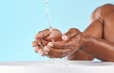 Image showing Water splash, hands and cleaning with beauty and black man, hygiene zoom and hydration with water mockup. Clean water drops, splash and skincare with natural cosmetics against blue studio background