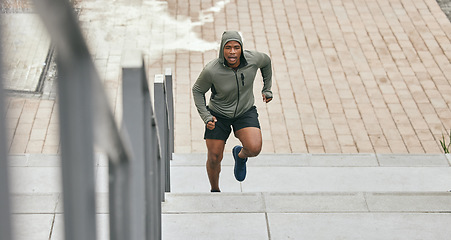 Image showing Fitness, runner or black man running on stairs for training, exercise or cardio workout in Chicago. Mission, mindset or healthy athlete in hoodie with motivation or sports goals exercising on steps