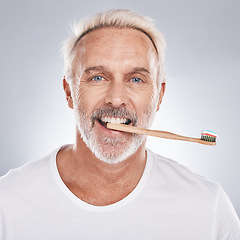 Image showing Dental care, hygiene and grooming man brushing teeth for healthy smile, mouth wellness and healthcare on a studio background. Oral care, toothbrush and face portrait of a senior model cleaning teeth