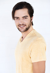 Image showing Fashion, happy and portrait of a man in a studio with casual, stylish and trendy clothes. Friendly, smile and young male model from Spain with a modern style outfit isolated by a white background.