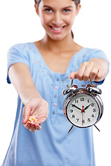 Image showing Pills, clock and portrait of a woman in a studio waiting to take medicine, vitamins or supplements. Tablets, health and female model with alarm as a medication reminder isolated by white background.