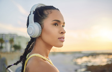 Image showing Headphones, exercise music and woman at beach thinking about training, exercising or workout. Sports, fitness and female athlete streaming radio, podcast or audio after running at sunset by ocean.