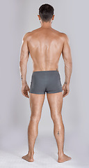 Image showing Man, body muscles and back on studio background for fitness check, workout training goals or exercise wellness power. Model, bodybuilder and strong athlete on gray backdrop for healthcare gym target
