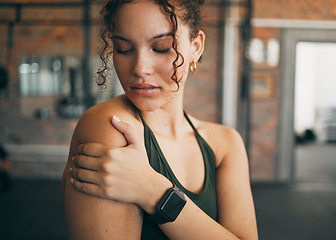 Image showing Woman, shoulder pain and muscle injury from sports workout, exercise or training at the gym indoors. Female holding arm after painful sport accident, inflammation or bruise from intense exercising