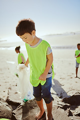 Image showing Environment, cleaning and children with pollution on beach for clean up, dirt and eco friendly volunteer. Sustainability, recycle and Asian boy reduce waste, pick up trash and plastic on beach sand