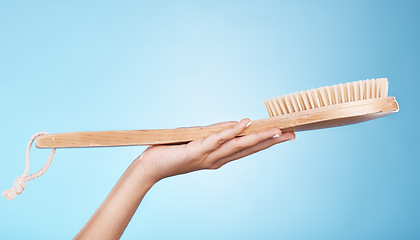 Image showing Woman, shower or bath hand brush for cleaning, hygiene and beauty grooming marketing. Model holding spa scrub treatment tool on blue studio background with mockup for cosmetic product.