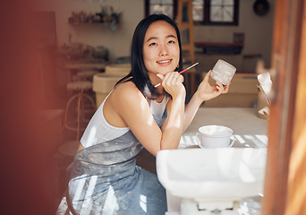 Image showing Asian woman, pottery and thinking while painting in workshop, creative studio and design startup. Happy female painter, clay ceramics and brush ideas, artistic pattern and dreaming in small business