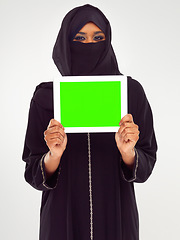 Image showing Muslim woman, tablet and green screen for marketing, advertising or mockup against a grey studio background. Portrait of woman in hijab holding touchscreen with green chromakey screen or display