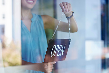 Image showing Small business, woman and entrepreneur with open sign excited at professional shop window entrance. Smile of proud and happy business owner holding sign for store opening with enthusiasm.