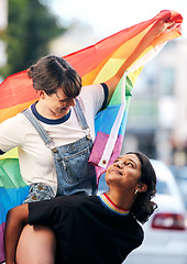 Image showing Women, lgbtq couple and piggyback with flag for pride, love and support in city street. Diversity, lesbian and gay friends celebrate rainbow identity, freedom and happiness of human rights together