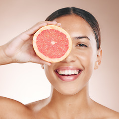 Image showing Skincare, diet glow and woman with a grapefruit, marketing health and smile for detox food on a studio background. Vitamin c, nutrition and portrait of a dermatology model with fruit for wellness
