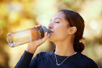 Image showing Fitness, nature and woman drinking water after running for hydration, refresh and thirst. Sports, runner and female athlete enjoying a drink after cardio training for a race, marathon or competition.