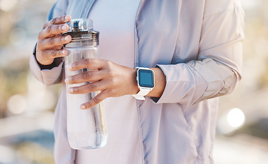 Image showing Water bottle, runner hands and outdoor fitness for training workout hydration, exercise rest and sports wellness. Athlete, running break and drinking water for morning cardio routine in nature park