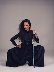 Image showing Sword, asian woman and warrior ninja or samurai in studio to fight for power, cosplay and fantasy. Strong japanese female in black fashion pose with beauty, action and metal weapon for art deco