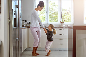 Image showing Kitchen dancing, mother and daughter in the morning at home with happiness dancing together. Mom, girl and parent care holding hands with a young kid in a house happy about family with a smile