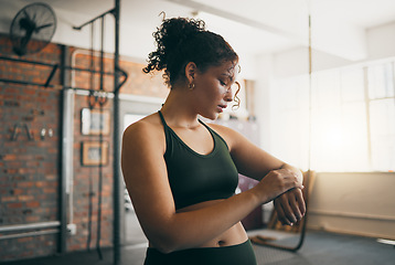 Image showing Fitness, smartwatch and gym workout progess of a woman doing exercise, training and body wellness. Young sports female or athlete with app for time while active to be strong, healthy and for energy