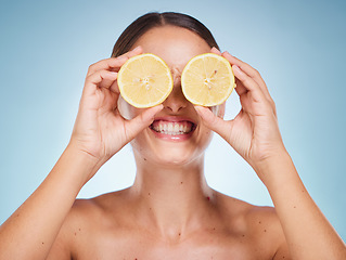 Image showing Beauty, lemon and skincare with a model woman in studio on a blue background for natural treatment. Wellness, luxury and fruit with an attractive young female posing to promote health or skin care