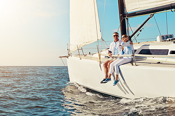 Image showing Yacht, travel or love and a mature couple sitting on a boat out at sea with blue sky mockup and flare. Ocean, summer and luxury with a man and woman on a ship to relax on the water in nature