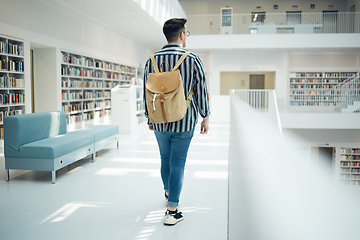 Image showing Backpack, library and education with a man student walking in a university bookstore for learning or development. Back, college and research with a male pupil taking a walk in search of a book