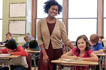 Image showing Education, learning and portrait of teacher with girl writing exam or test at Montessori school with students. Black woman, happy children at desk and monitoring growth and development for school kid