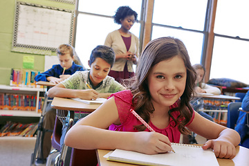 Image showing Education, girl and portrait writing in classroom with notebook for lesson notes and knowledge. School kids, learning and development of middle school children with books and supervision.