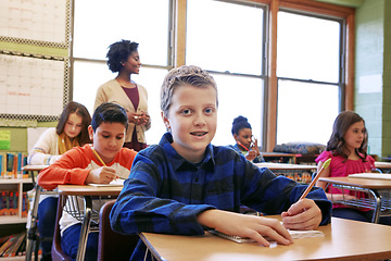 Image showing Education, boy and student portrait in classroom with notebook for lesson notes and knowledge. School kids, learning and development of middle school children writing in books with happy teacher