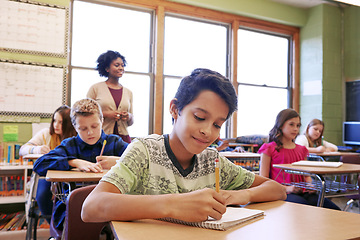 Image showing Child, education or student in classroom writing in notebook for learning, research or study for exam with teacher. Scholarship, thinking or happy kid in school for test, academy or assessment