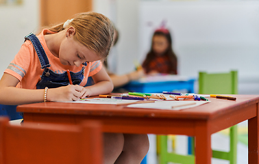 Image showing Creative kids sitting in a preschool institution, draw and have fun while they get an education