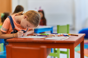 Image showing Creative kids sitting in a preschool institution, draw and have fun while they get an education